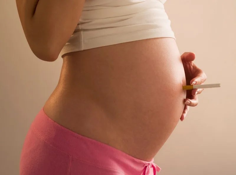 Pregnant woman holding a cigarette