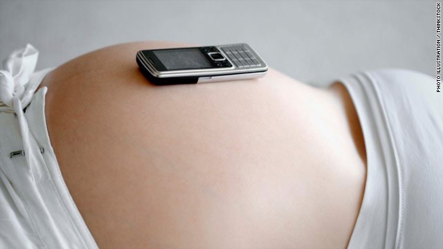 Mobile phone resting on a pregnant woman's belly